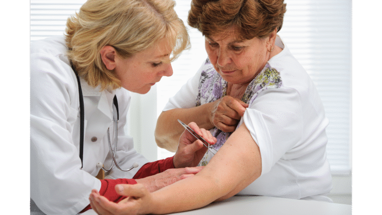 Lekarka bada skórę starszej kobiety za pomocą dermatoskopu.