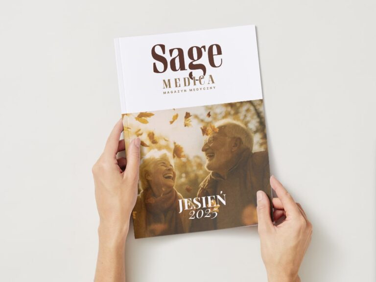 Osoba trzyma w dłoniach jesienny numer magazynu „Sage Medica” z okładką przedstawiającą uśmiechniętą starszą parę wśród spadających liści.