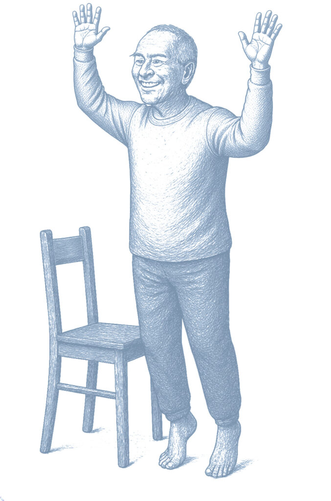 Starszy mężczyzna stoi na palcach z uniesionymi rękami, ćwicząc równowagę obok krzesła.