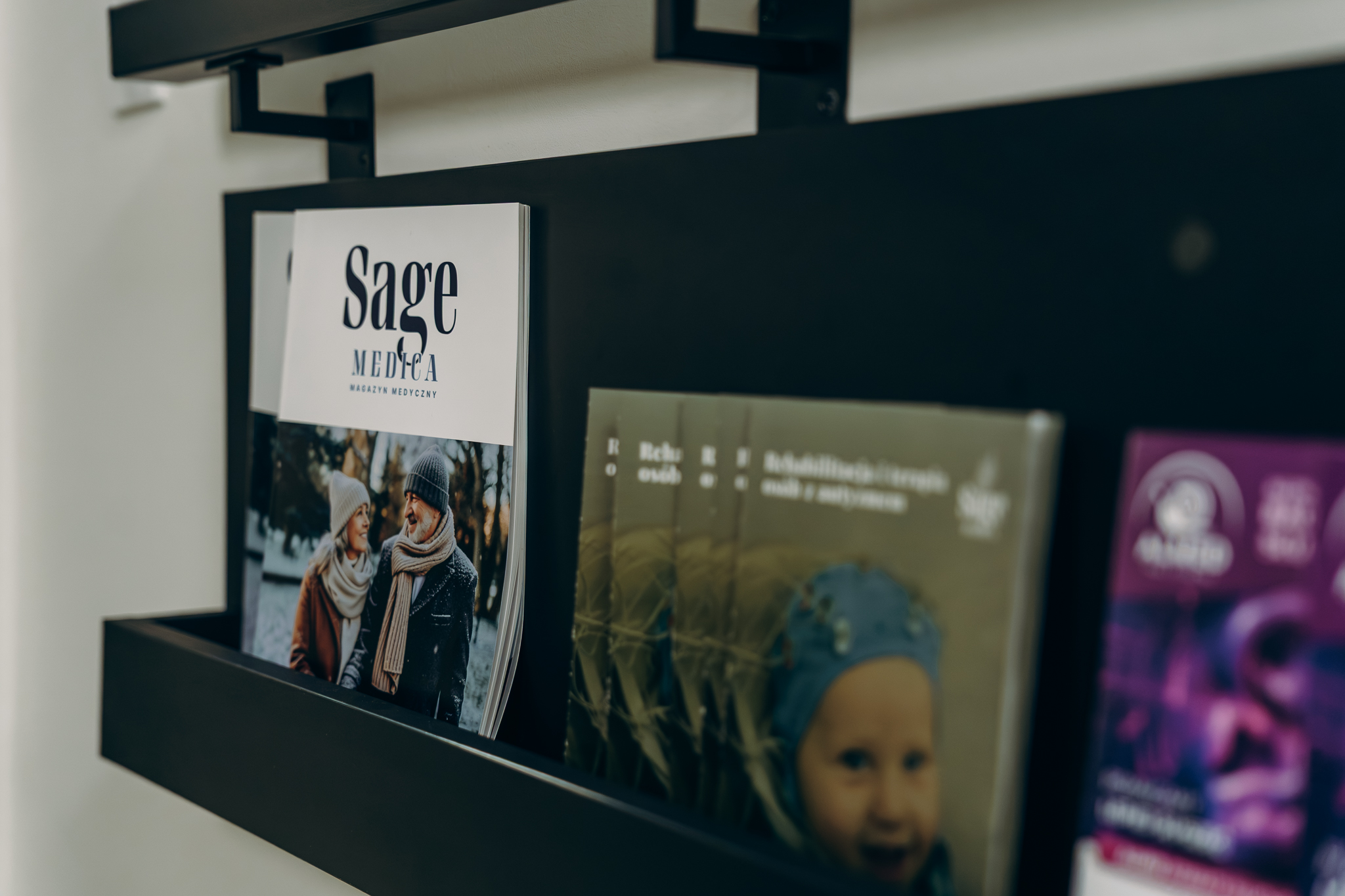 zdjęcie pokazuje materiały reklamowe i edukacyjne na półce, magazyn edukacyjny Sage MEdica - Magazyn Medyczny i ulotkę informacyjną usług poradni psychologicznej